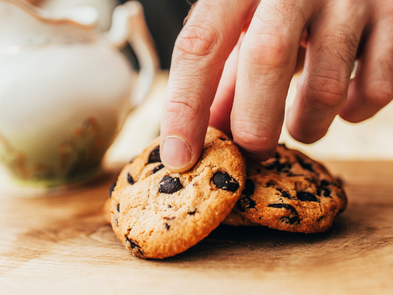man reaching for a sugary cookie